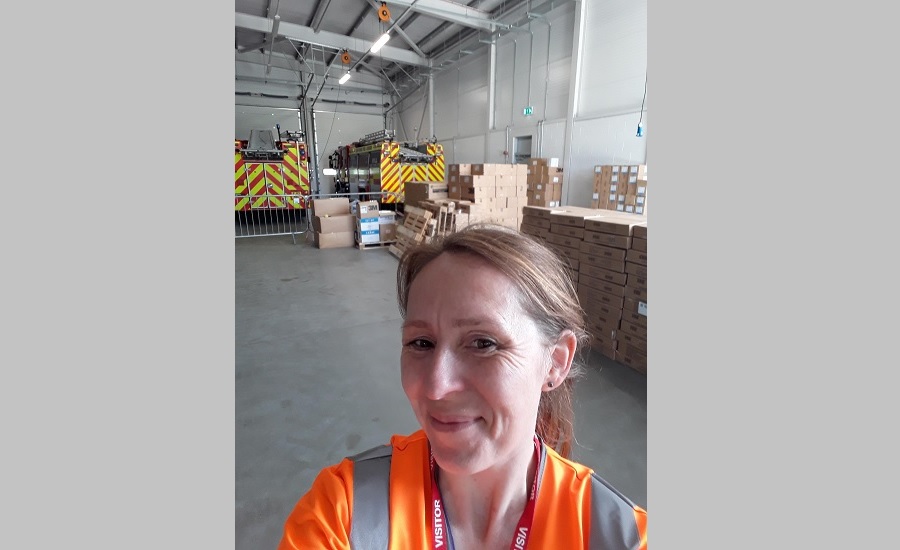 Alice standing in front of boxes of PPE