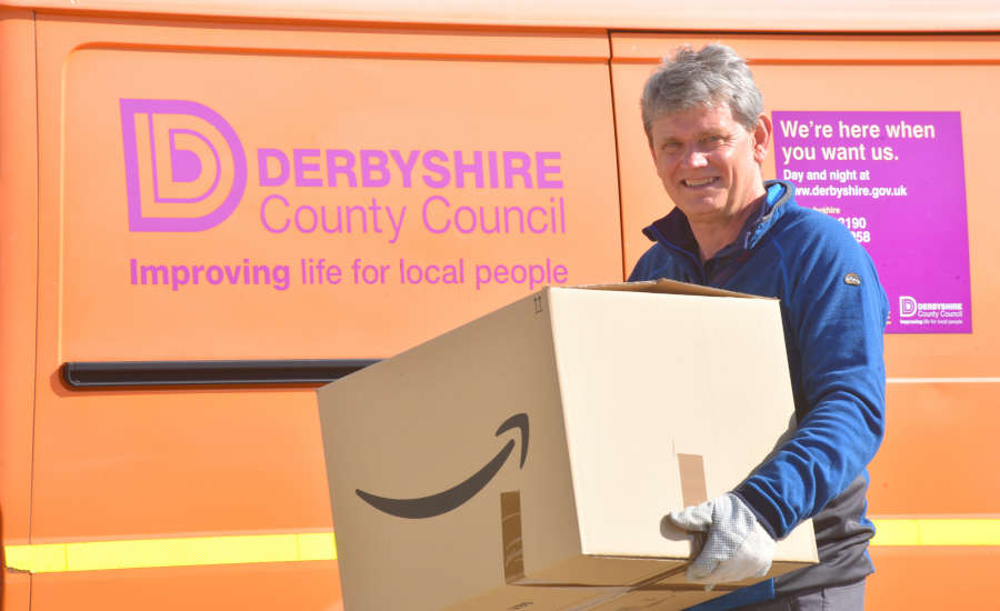 Man holding a box standing in front of a council van