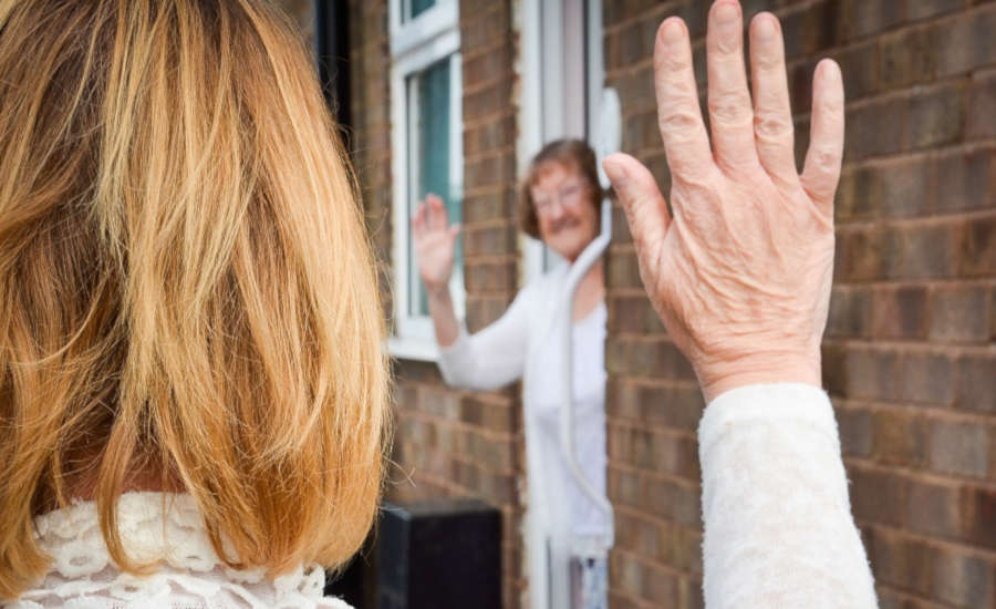 Two people waving at doorstep
