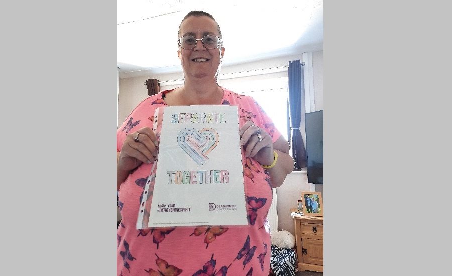 Lynda broom holding a separate together poster