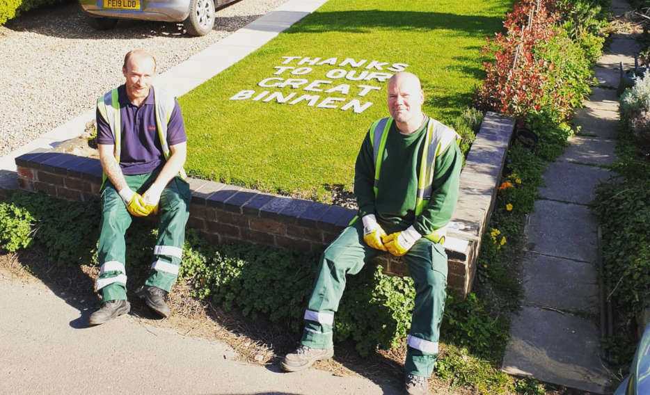 Refuse collectors sitting on a wall with thank you message